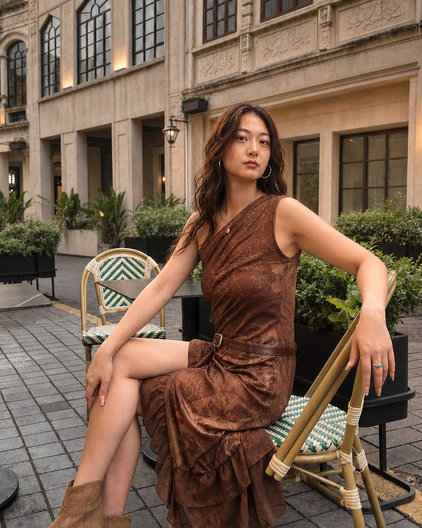 Seated view showing the drape of the Nomad Tide one-shoulder dress in Tobacco Brown