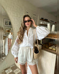 Mid-length view of the relaxed white embroidered blouse