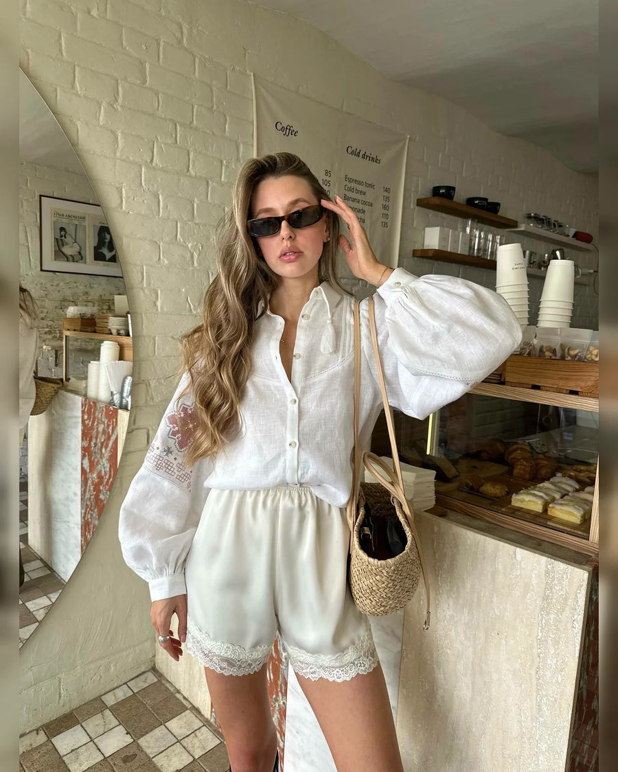 Mid-length view of the relaxed white embroidered blouse