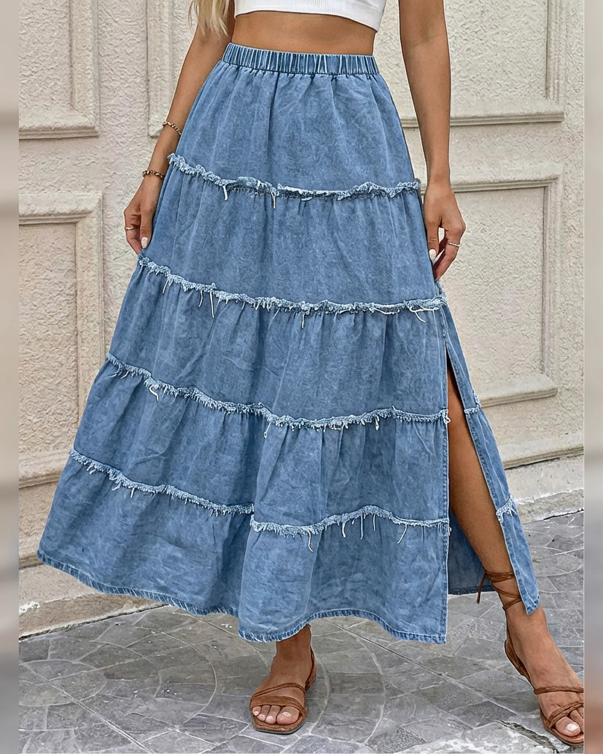 Front view of the light blue raw-edge tiered denim maxi skirt